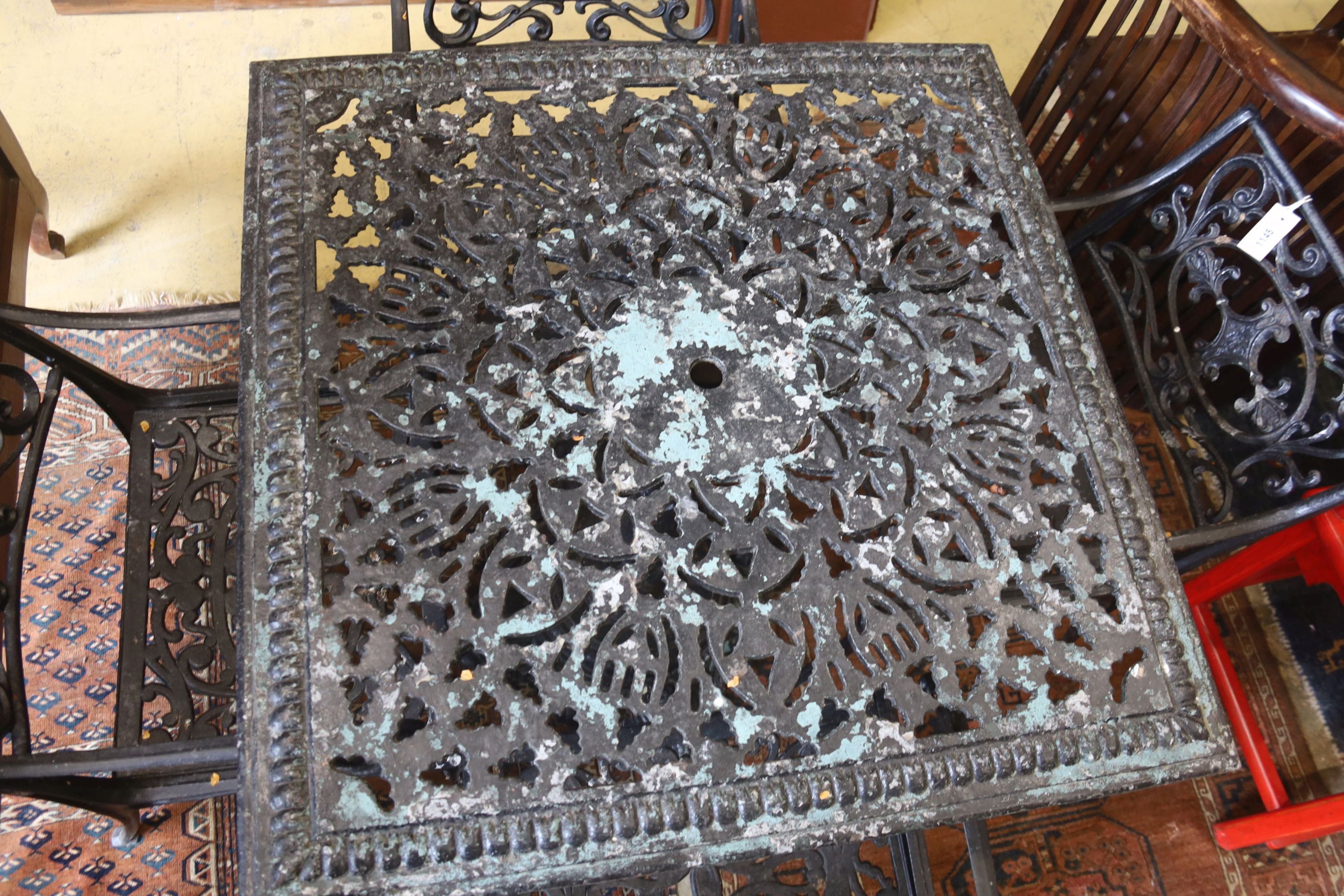 A Victorian style square cast metal garden table, width 88cm, height 72cm and four elbow chairs (one a.f.)